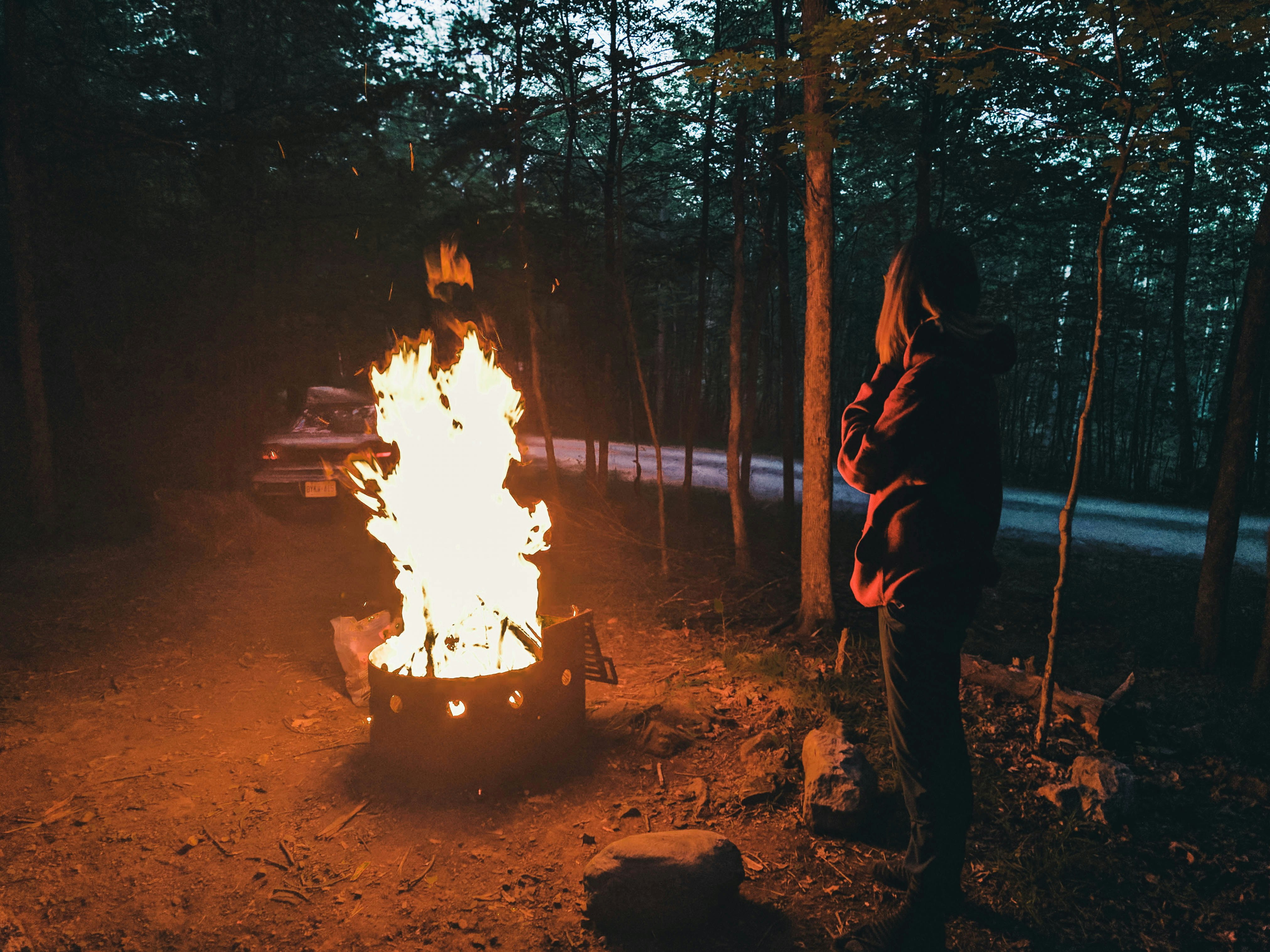 man in black jacket and black pants standing near bonfire during night time